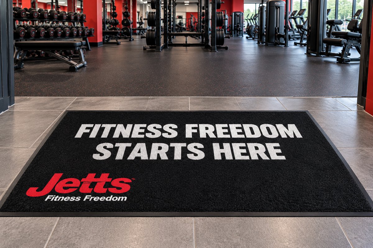 Black logo mat reading Fitness Freedom Starts Here with the Jetts logo