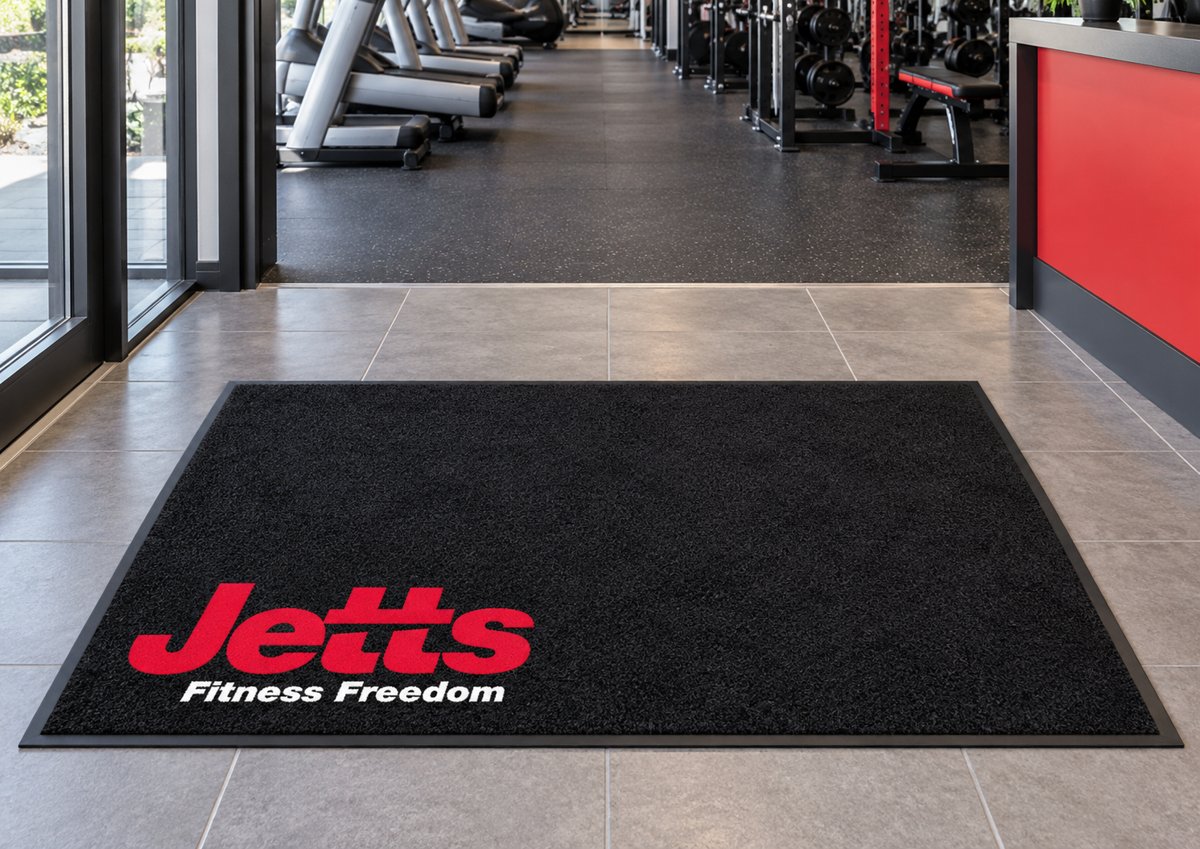Black logo mat with the Jetts Fitness Freedom logo in the corner