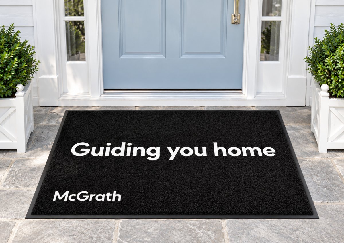 Black logo mat reading Guiding you home with the McGrath logo