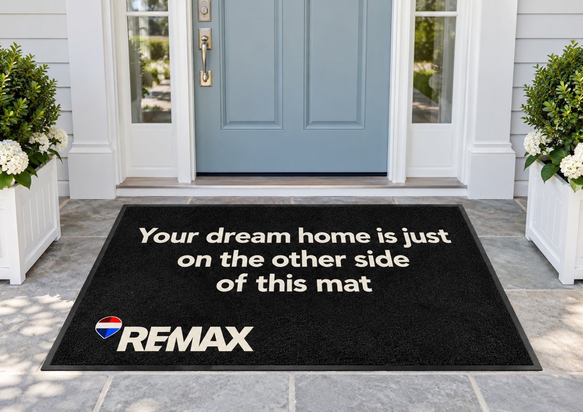 Black mat reading Your dream home is just on the other side of this mat with the RE/MAX logo