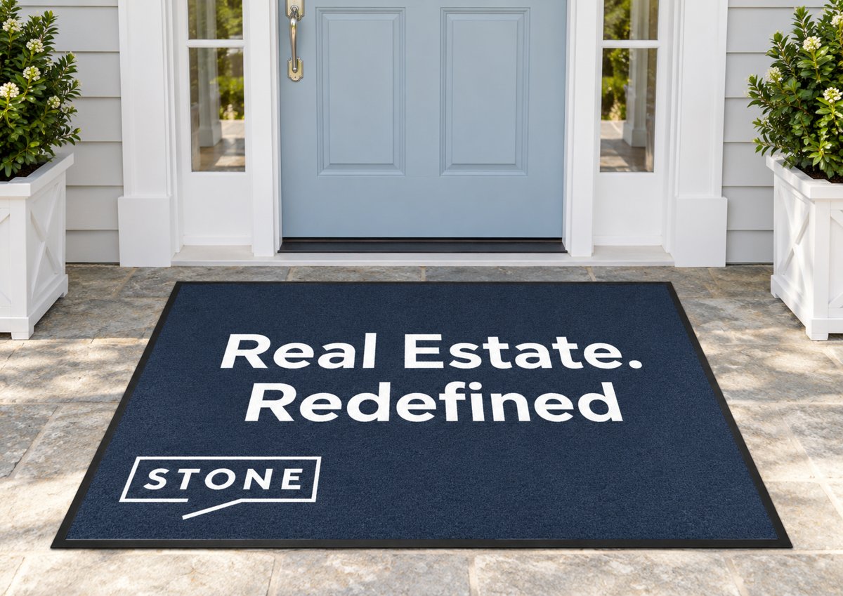 Navy logo mat reading Real Estate. Redefined with the Stone logo