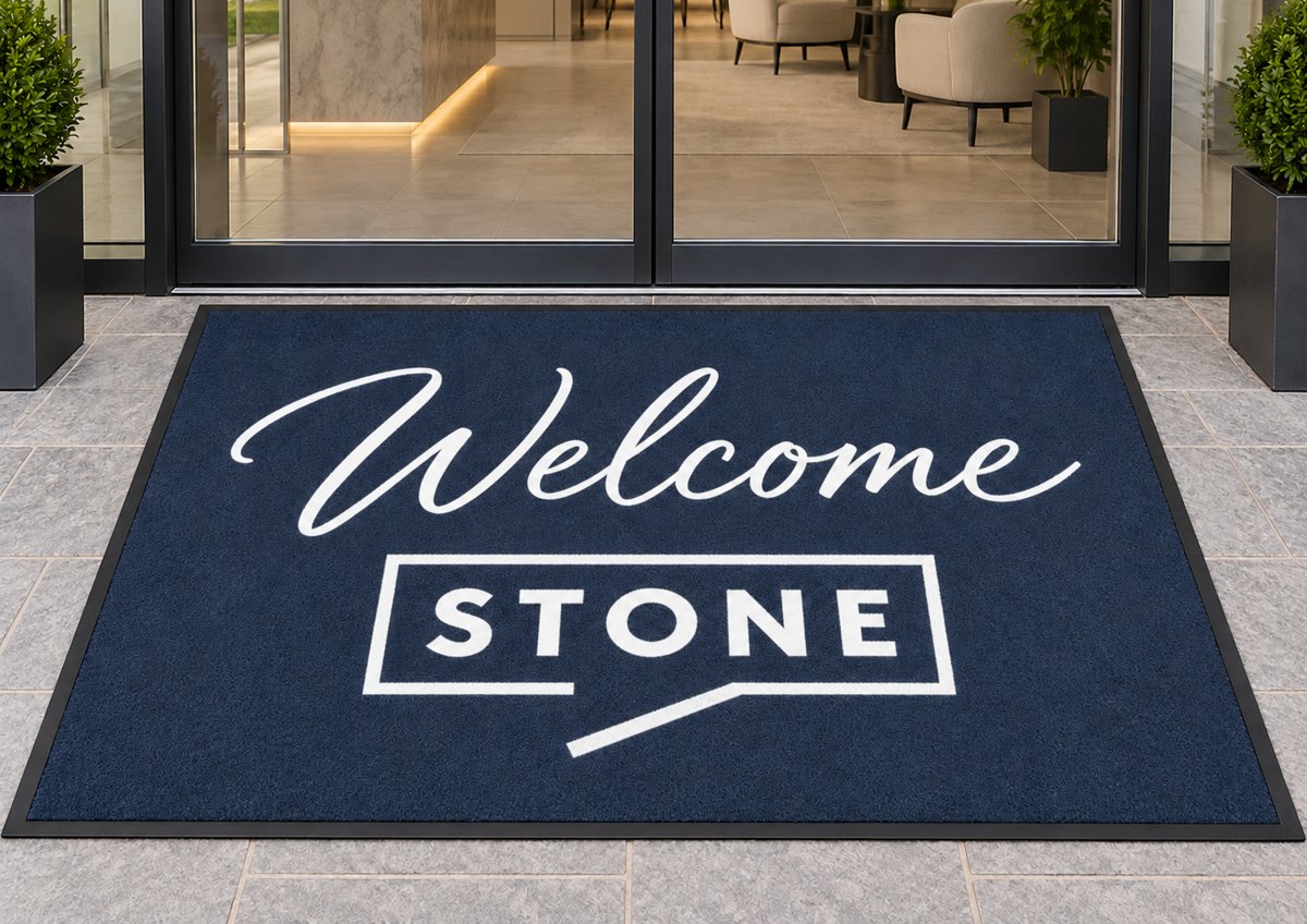 Welcome Stone Real Estate logo mat at an office entrance